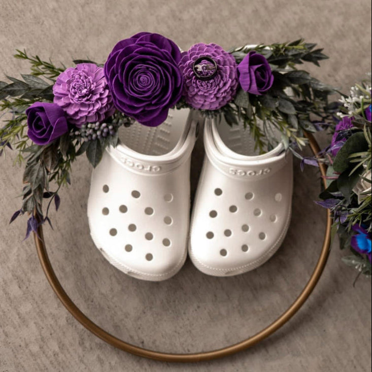 White Crocs with floral arrangement on a beige background